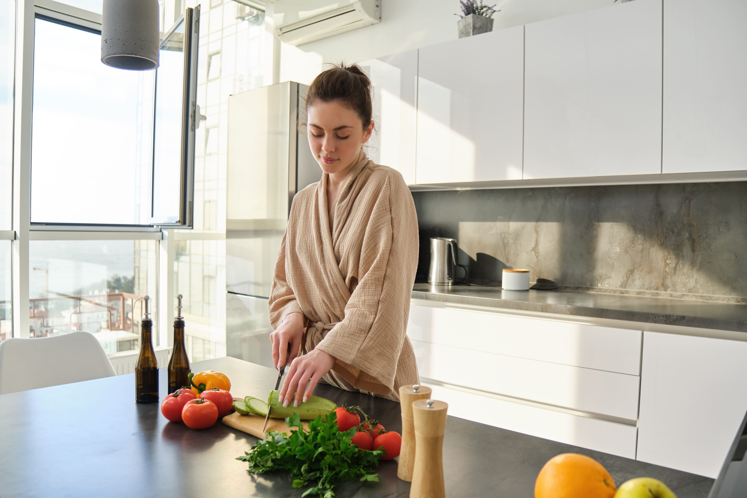 retrato-de-una-mujer-cocinando-el-desayuno-cortando-verduras-para-ensalada-usando-una-tabla-y-un-cuchillo-de-pie.